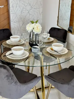 a glass table with plates and glasses and a vase with flowers at M Luxury Home In Irene Centurion-No Blackouts in Centurion