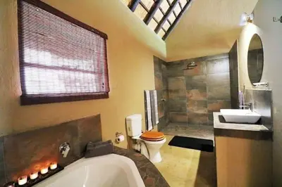 a bathroom with a tub and a toilet and a sink at Leopard Rock Guest Lodge in Mica