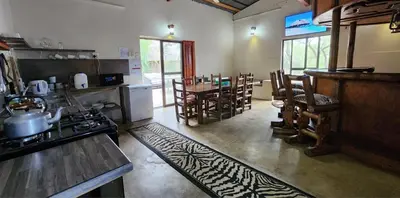 a kitchen with a stove and a table and chairs at Leopard Rock Guest Lodge in Mica