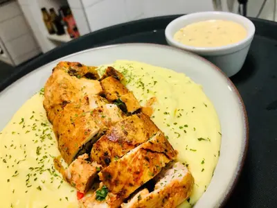 a plate of food with chicken and a dipping sauce at 30 on Bergh in Louis Trichardt