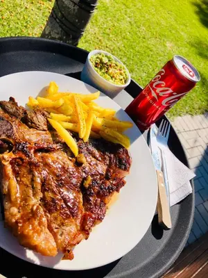 a plate of food with french fries and a soda at 30 on Bergh in Louis Trichardt