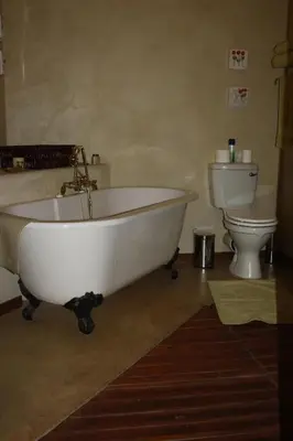 a bathroom with a white tub and a toilet at Thandile Country Lodge in Bela-Bela