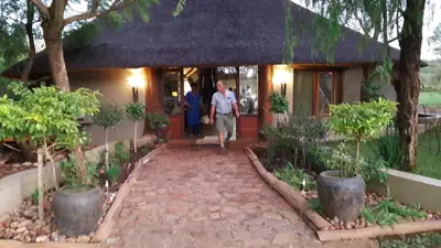 a man walking out of a house at Timbaktu River Cottages in Moheme