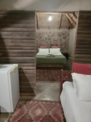 a small room with two beds and a refrigerator at Timbaktu River Cottages in Moheme