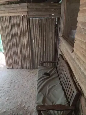 a bench with a pillow on it in a room at Timbaktu River Cottages in Moheme