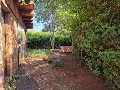 a garden next to a house with a fence at Hartbees Bush Stay #1 in Hartbeespoort