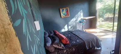 a bedroom with a bed with red pillows on it at Hartbees Bush Stay #1 in Hartbeespoort