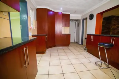 a large kitchen with wooden cabinets and a tile floor at Adondo-fast accommodation in Pretoria