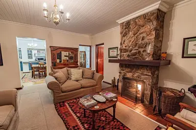 a living room with a couch and a fireplace at Crossroads Cottage in Dullstroom