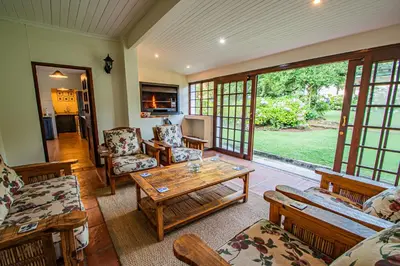 a living room filled with furniture and a table at Crossroads Cottage in Dullstroom