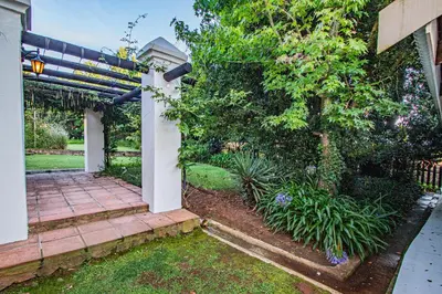 a house with a garden with a tree at Crossroads Cottage in Dullstroom