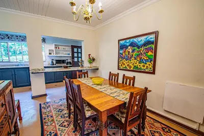 a dining room with a table and a painting on the wall at Crossroads Cottage in Dullstroom