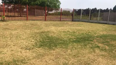 a large yard with a red fence and grass at Home Way Studio Sleeps 2 with Garden in Springs
