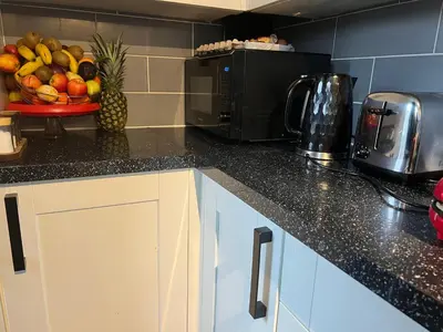 a kitchen counter with a bowl of fruit and a microwave at Home Way Studio Sleeps 2 with Garden in Springs