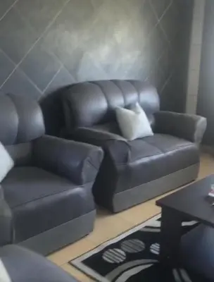 a living room with a leather couch and a table at Home Way Studio Sleeps 2 with Garden in Springs