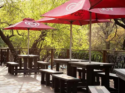 a group of picnic tables with umbrellas on a deck at Mabalingwe Elephant Lodge 256A in Moheme