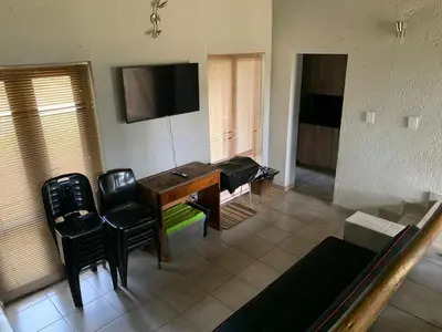 a living room with a desk and chairs and a television at Mabalingwe Elephant Lodge 256A in Moheme