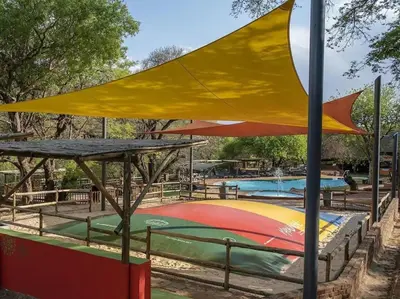 a playground with a yellow umbrella over a pool at Mabalingwe Elephant Lodge 256A in Moheme