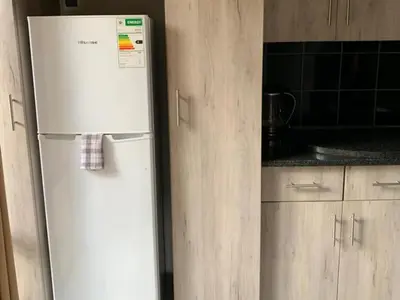 a white refrigerator in a kitchen with wooden cabinets at Mabalingwe Elephant Lodge 256A in Moheme
