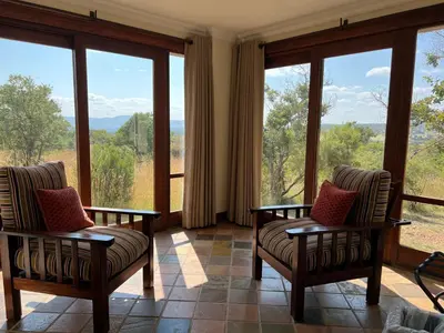 a room with two chairs and large windows at 211 Zebula in Mabula