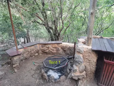 a stone fire pit with a sign that reads tent at Rustic Unique - Bush Glamping Retreat in Kalkheuvel