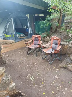 two chairs sitting in front of a tent at Rustic Unique - Bush Glamping Retreat in Kalkheuvel