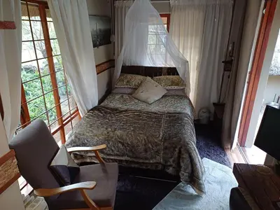 a bedroom with a bed with a mosquito net over it at Rustic Unique - Bush Glamping Retreat in Kalkheuvel