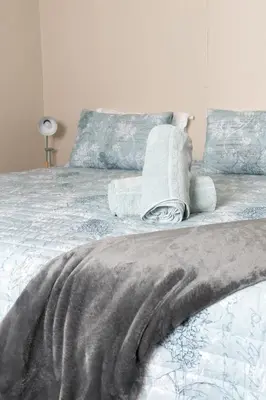 a bed with towels and pillows on top of it at Country Side Cottage @ Low's Creek in Louwʼs Creek