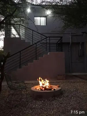 a fire pit in a yard with a chair and stairs at Giraffe Studio @ Kruger in Marloth Park
