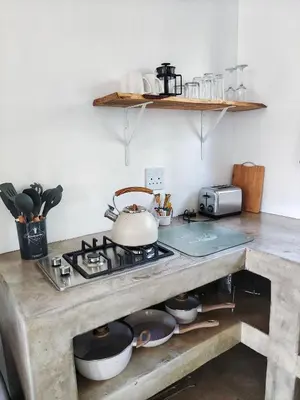 a kitchen with a stove with pots and pans at Giraffe Studio @ Kruger in Marloth Park