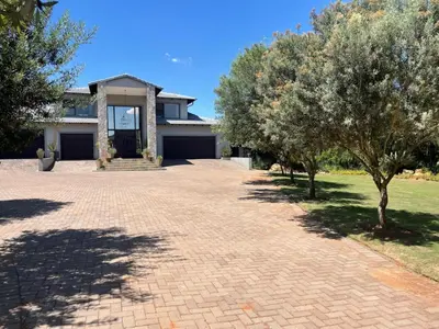 a brick driveway with trees in front of a house at The Lodge on Ilona in Tierpoort