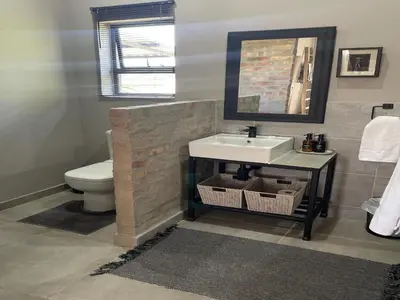a bathroom with a sink and a toilet at The Lodge on Ilona in Tierpoort
