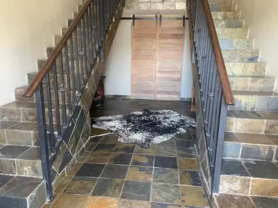 a rug on the floor in a hallway with stairs at The Lodge on Ilona in Tierpoort