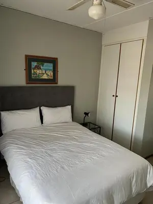 a bedroom with a large bed with white sheets at 86 Pendleberry Holiday Grove in Warmbaths