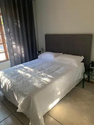 a bedroom with a large bed with white sheets at 86 Pendleberry Holiday Grove in Warmbaths
