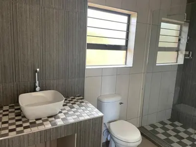 a bathroom with a toilet and a sink and a tub at Sonop in Marloth Park in Marloth Park