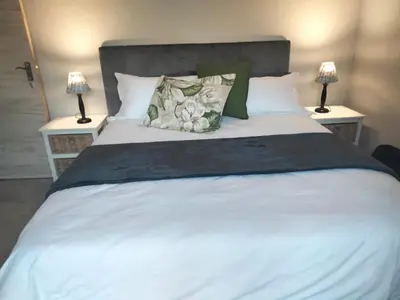 a white bed with two lamps on either side of it at Sonop in Marloth Park in Marloth Park