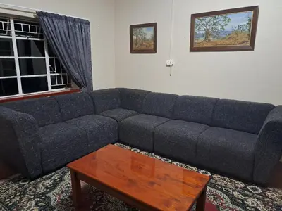 a living room with a couch and a coffee table at Pine Forest Cottage in Sabie