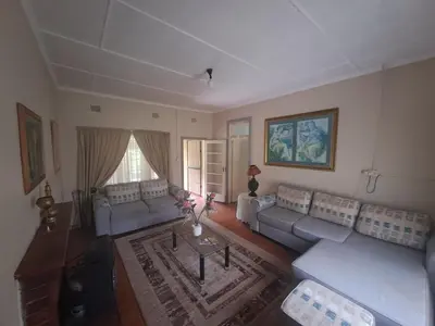 a living room with couches and a coffee table at Pine Forest Cottage in Sabie