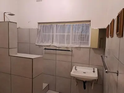 a bathroom with a sink and a window at Pine Forest Cottage in Sabie