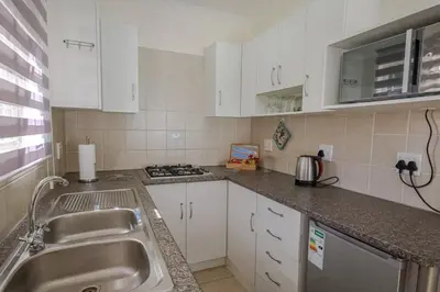 a small kitchen with a sink and a stove at The Lemon Tree Oasis - Solar in Centurion