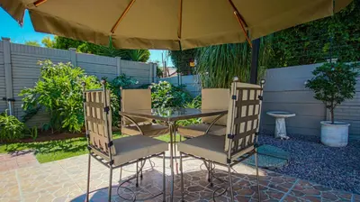 a table and chairs under an umbrella on a patio at The Lemon Tree Oasis - Solar in Centurion