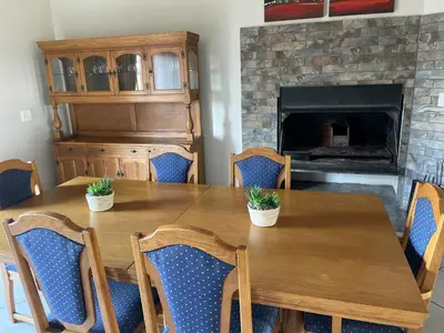 a dining room table with chairs and a fireplace at On-Nkwe accommodation in Tierpoort