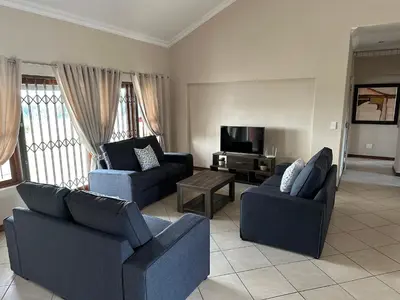 a living room with two couches and a tv at On-Nkwe accommodation in Tierpoort