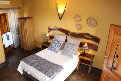 a bedroom with a bed with blue and white pillows at Ndlovu Lodge in Pretoria