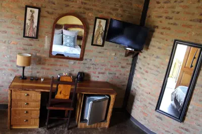a bedroom with a desk and a mirror and a bed at Ndlovu Lodge in Pretoria