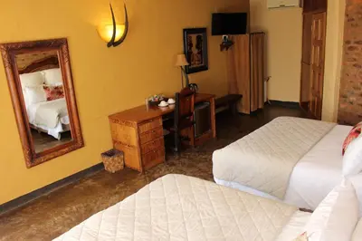 a hotel room with two beds and a mirror at Ndlovu Lodge in Pretoria