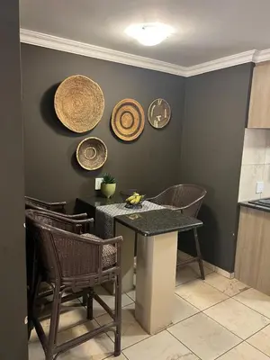 a kitchen with a table and chairs and plates on the wall at Sable Ranch Bush Lodge in Brits