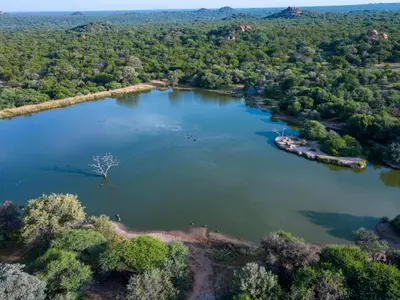 an aerial view of a large lake with trees at Sable Ranch Bush Lodge in Brits