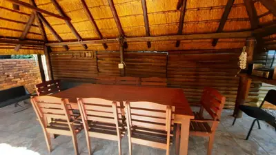 a dining room with a wooden table and chairs at Legaeng Cottage - Serenity in Pretoria